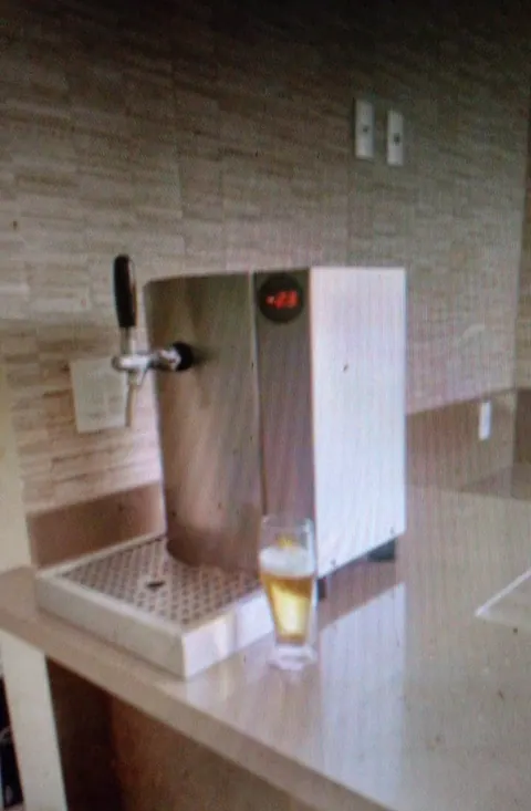 Chopeira de expansão de inox, com visor digital e uma torneira, e um copo de chope