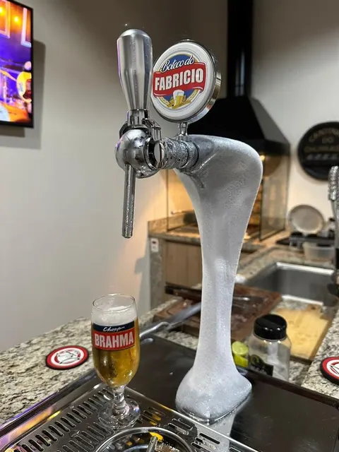 Torre Naja coberta de gelo, com uma torneira e um copo de chope ao lado